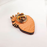 A unique, handcrafted wooden keychain shaped like an anatomical heart with a gold metal key ring attached, placed on a white surface with soft lighting.