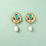 A pair of handcrafted gold-toned Basic Drop Earrings with turquoise accents and dangling white pearls, displayed on a light green background.