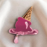 The handcrafted Melted Ice Cream Brooch, shaped like a melting pink cone with a waffle base, lies on soft beige satin—perfect for adding charm to your summer wardrobe.