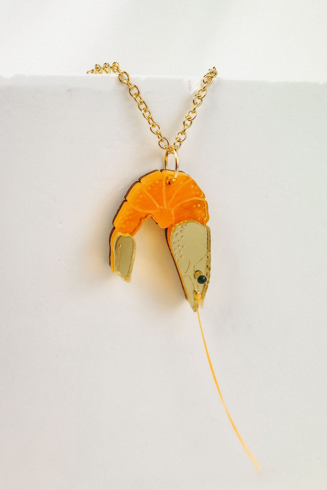 A whimsical gold Shrimp Pendant Necklace featuring a realistic orange and beige shrimp, displayed against a plain white background for a playful touch.