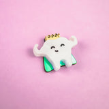 A cute Tooth King Pin enamel pin featuring a smiling, crown-wearing tooth with raised arms, set against a pink background—a charming handcrafted accessory for any collection.